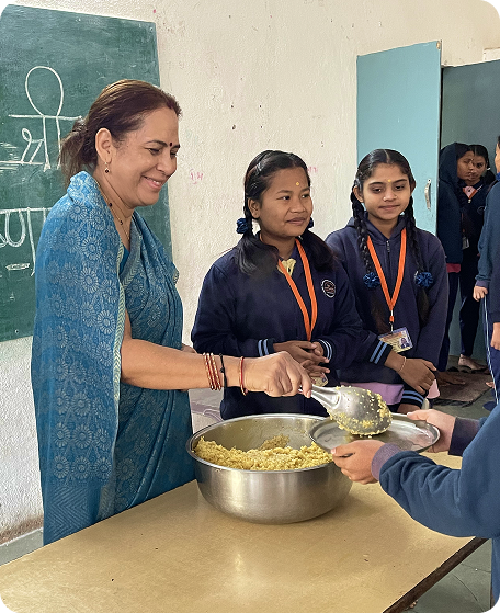 A joyful moment serving food to the students at the Inder & Prabha Sharma Girls School